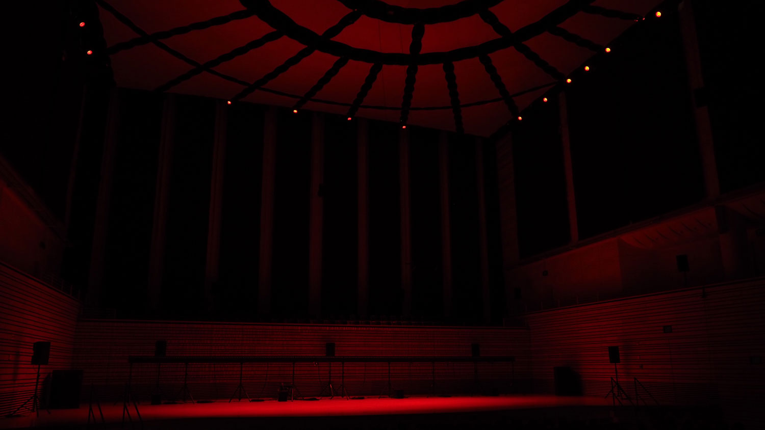 The empty concert hall bathed in deep red light. 