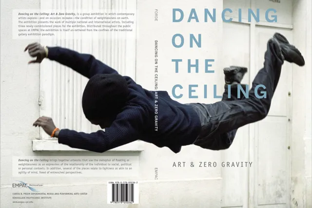 A person in a hooded sweatshirt mid-air falling in front of a white building, Dancing on the Ceiling 