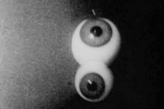 Surreal image of two human eyeballs stacked vertically. 