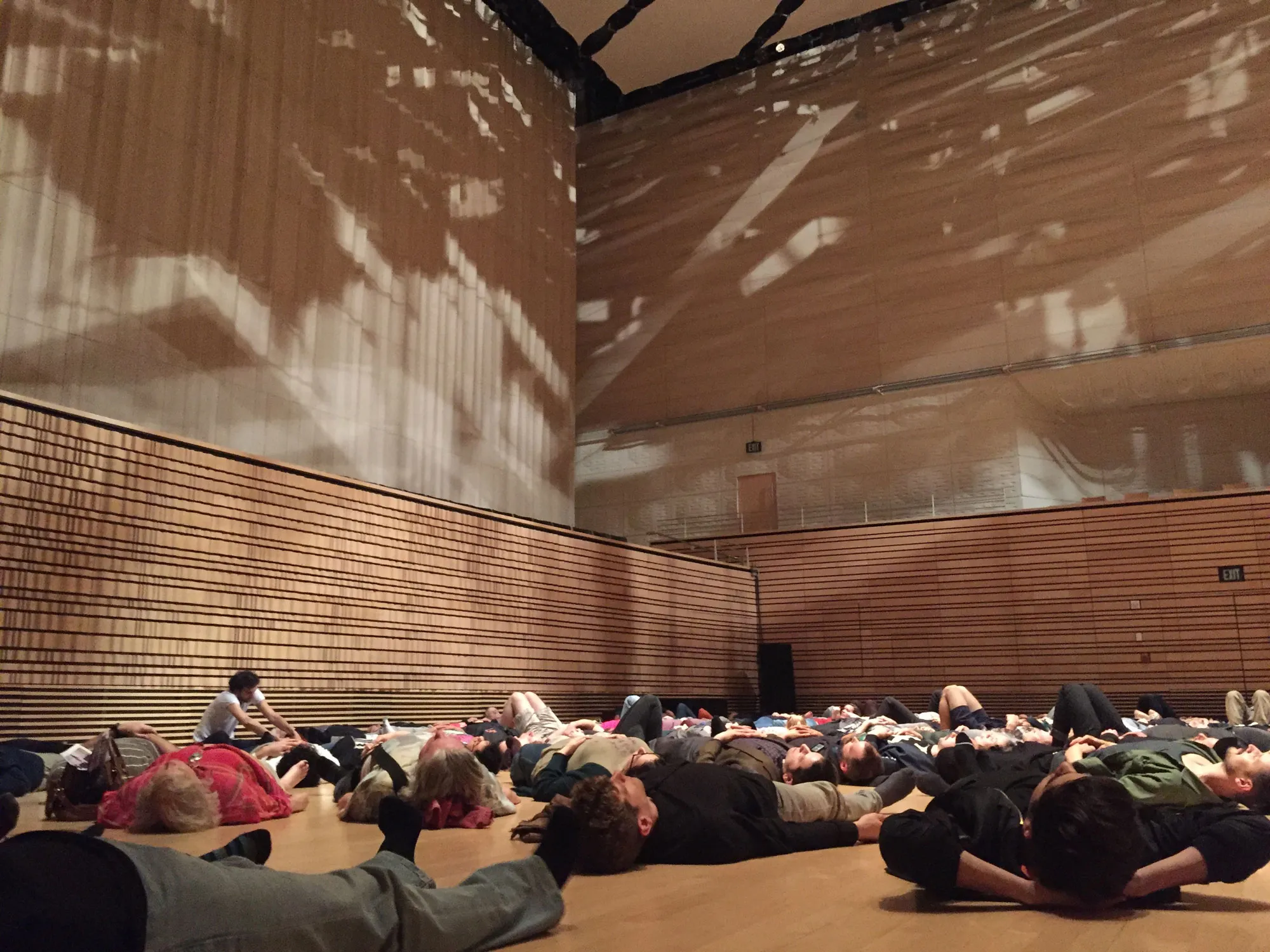 A crowd of people laying on their backs across the Concert Hall stage.