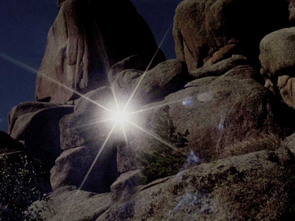 a desert cliff with a starburst reflection 