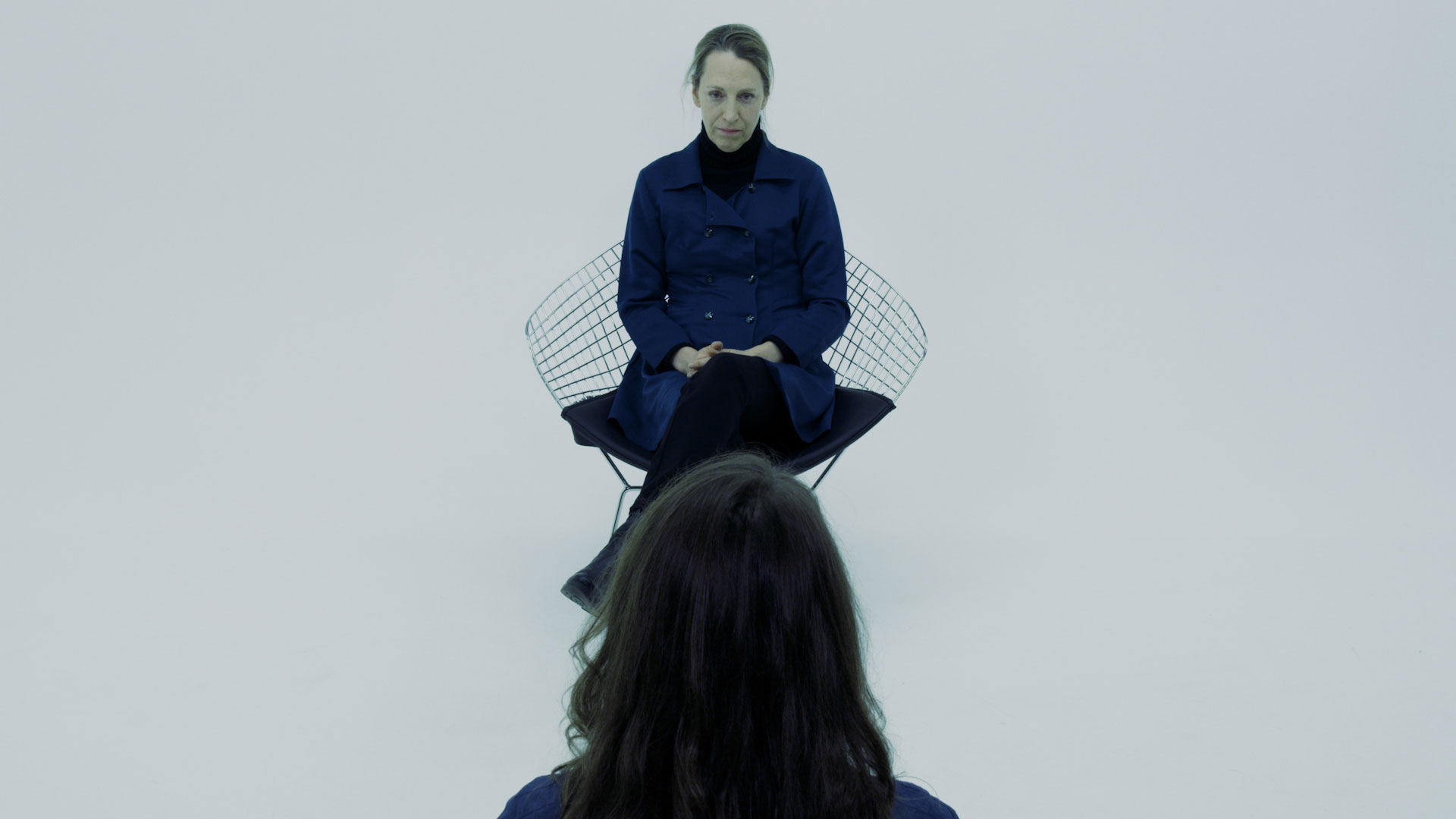 a woman faces a woman in a chair