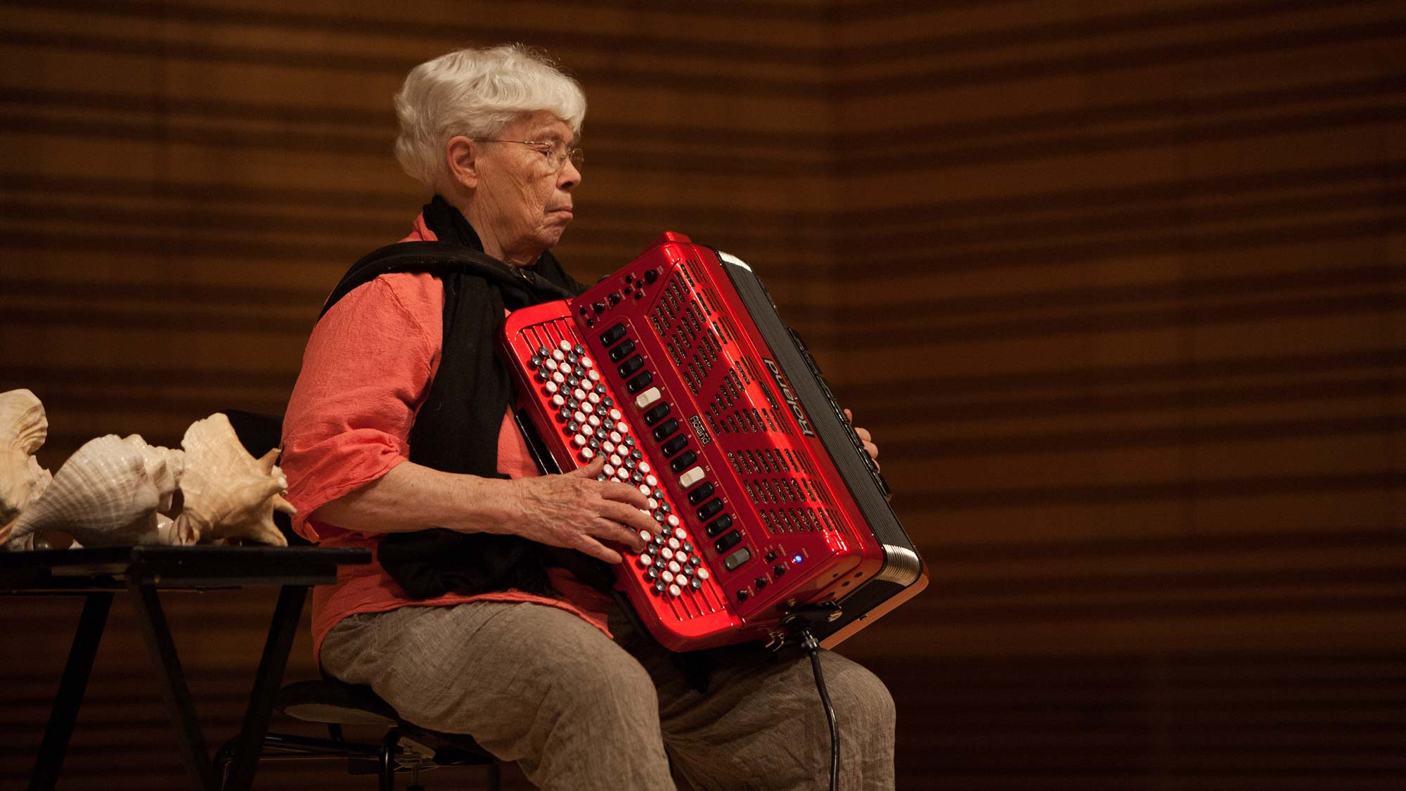 pauline oliveros seated playing her red accordion