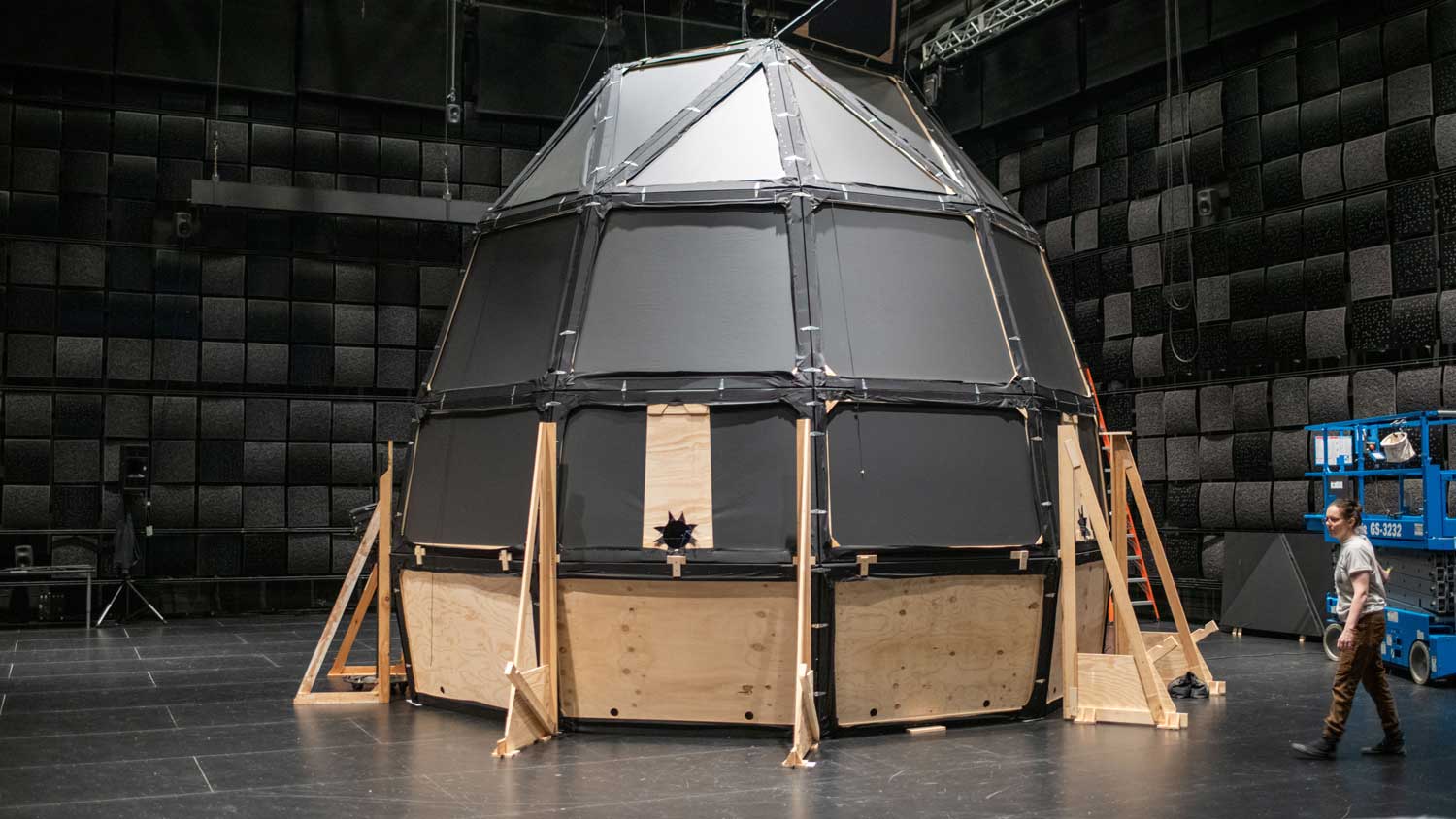 a spaceship-like structure covered in black fabric in studio1