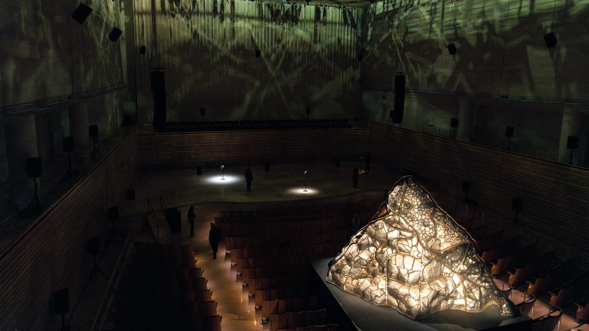 a steel volcano sits in the middle of the concert hall with dramatic lighting