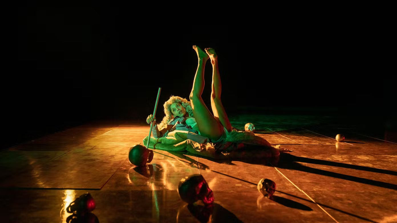 a woman laying on stage with her legs in the air