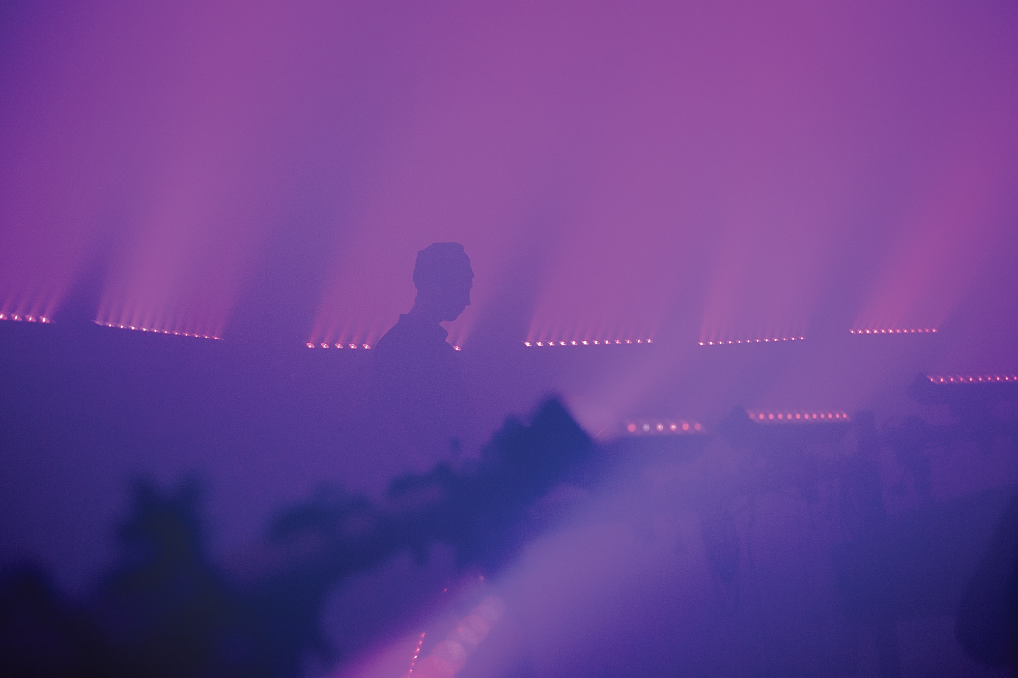 tim hecker's silhouette in dense purple theatrical fog 