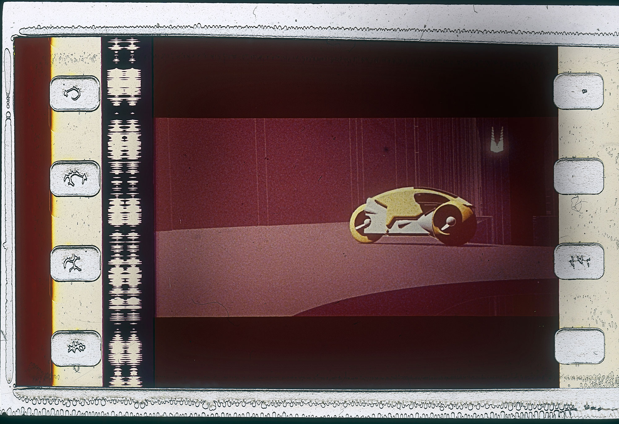 a celluloid still of a small yellow vehicle. 