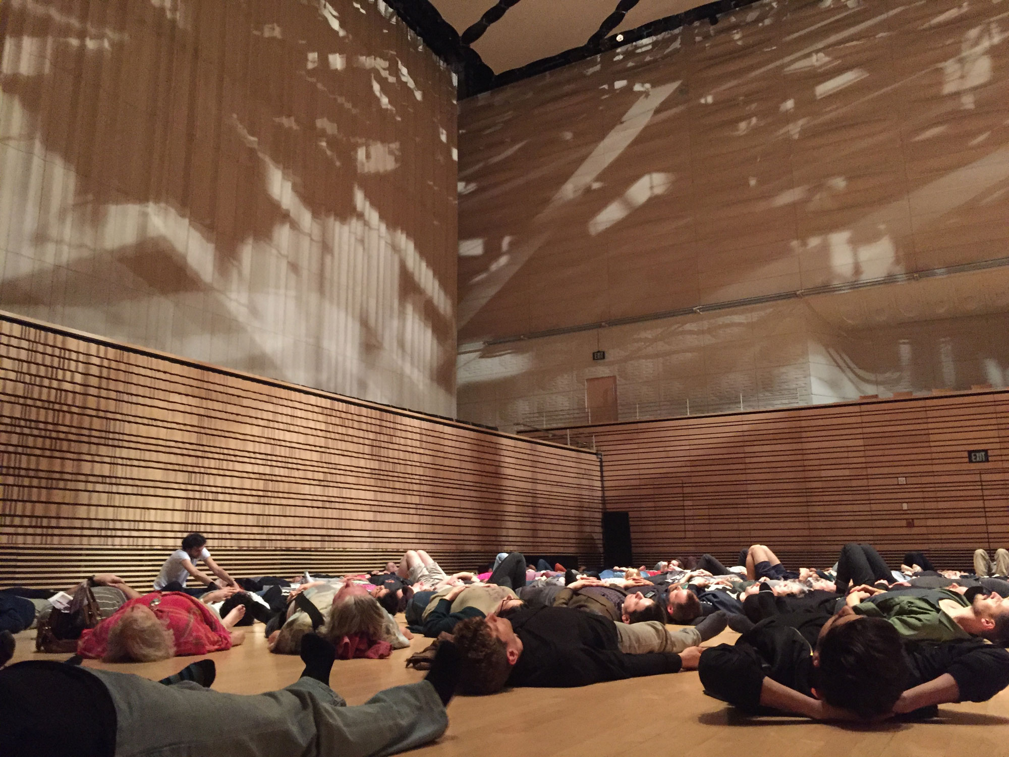 A crowd of people laying on their backs across the Concert Hall stage.