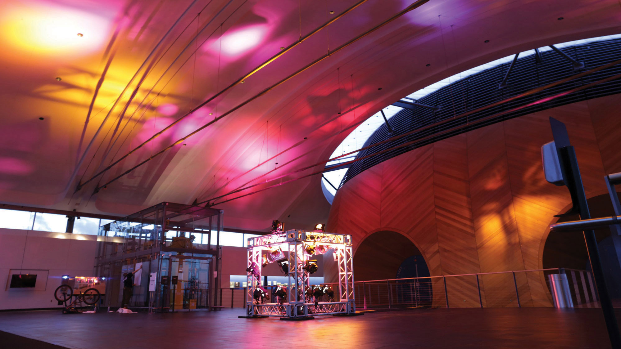 EMPAC Lobby lit in pink and orange spots of light via a lighting rig set up in the middle of the floor. 