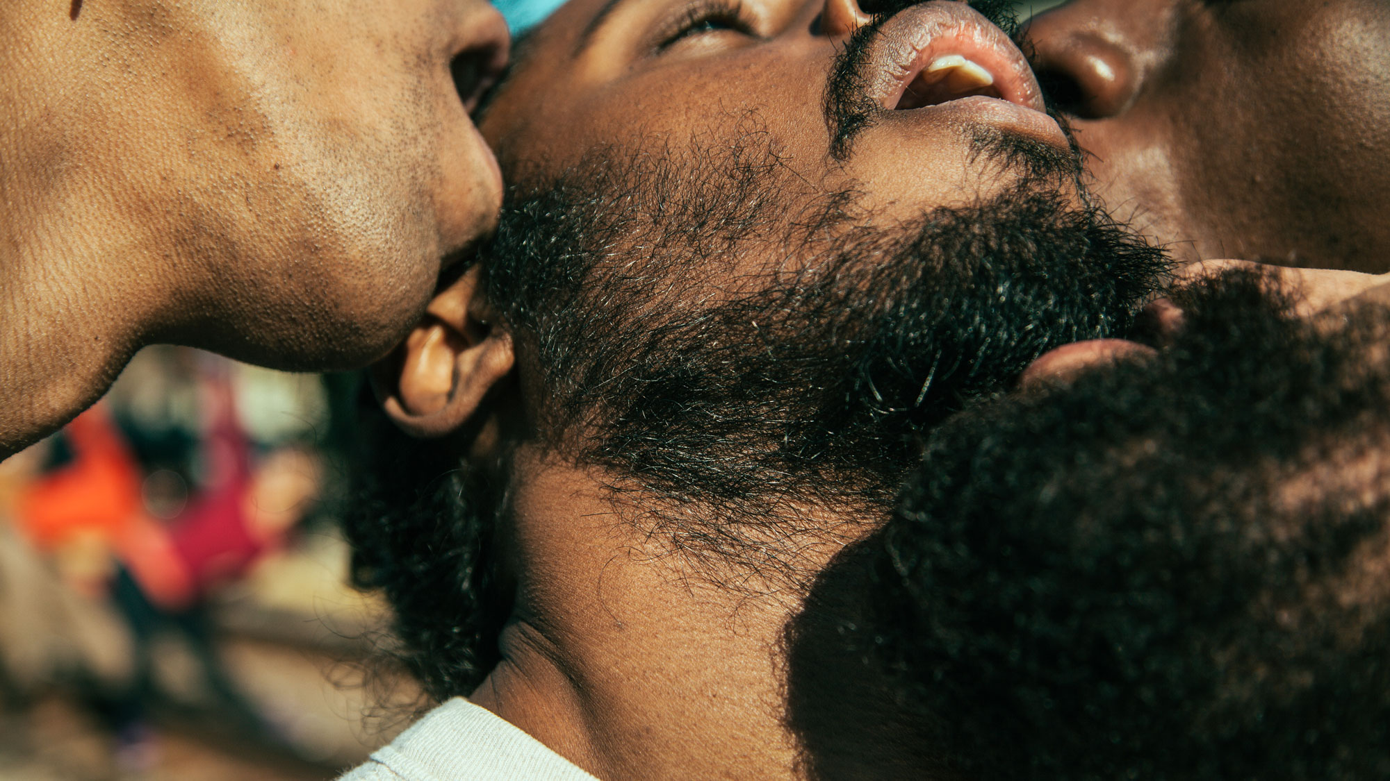 Four Black men in close proximity with mouths open creating a sexual scene. 