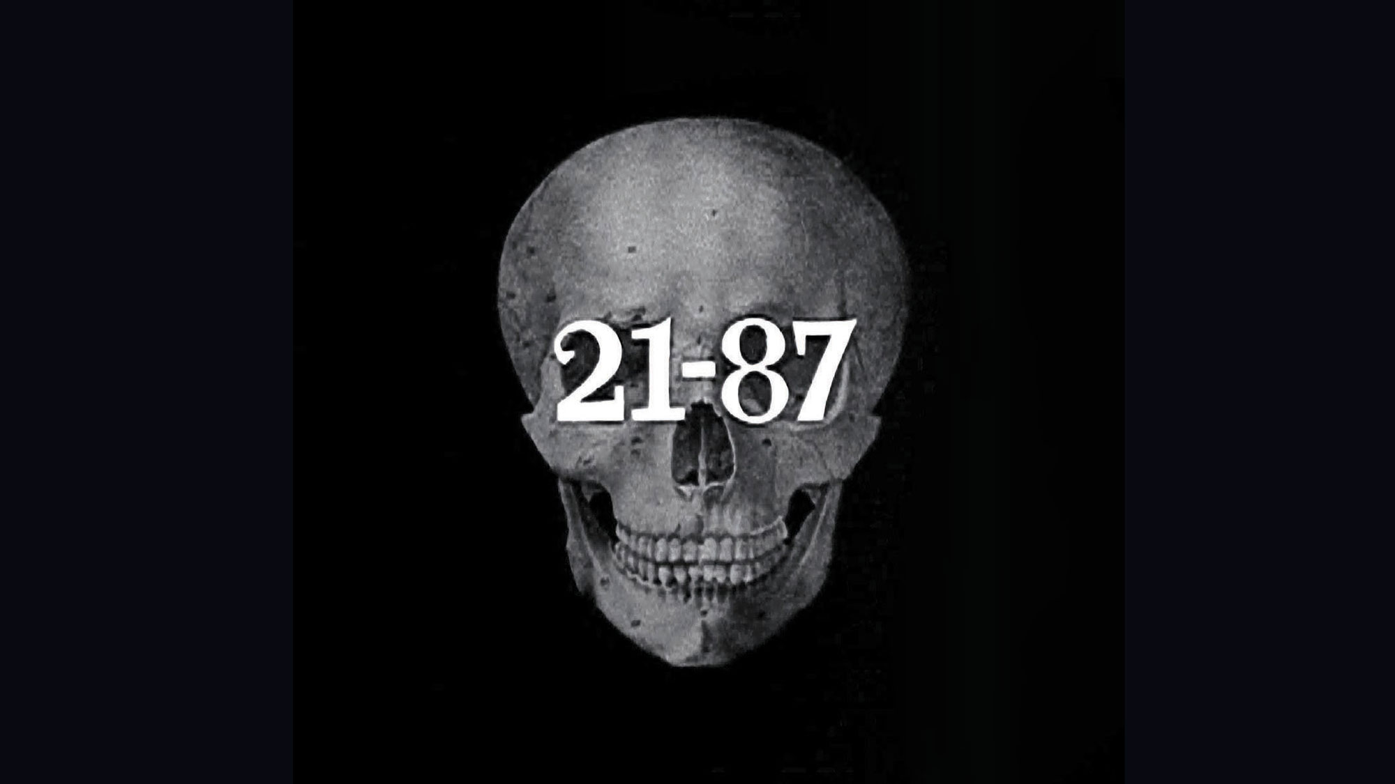 An illustration of a human skull facing forward with the numbers "21-87: across the eyes in white bold font. 