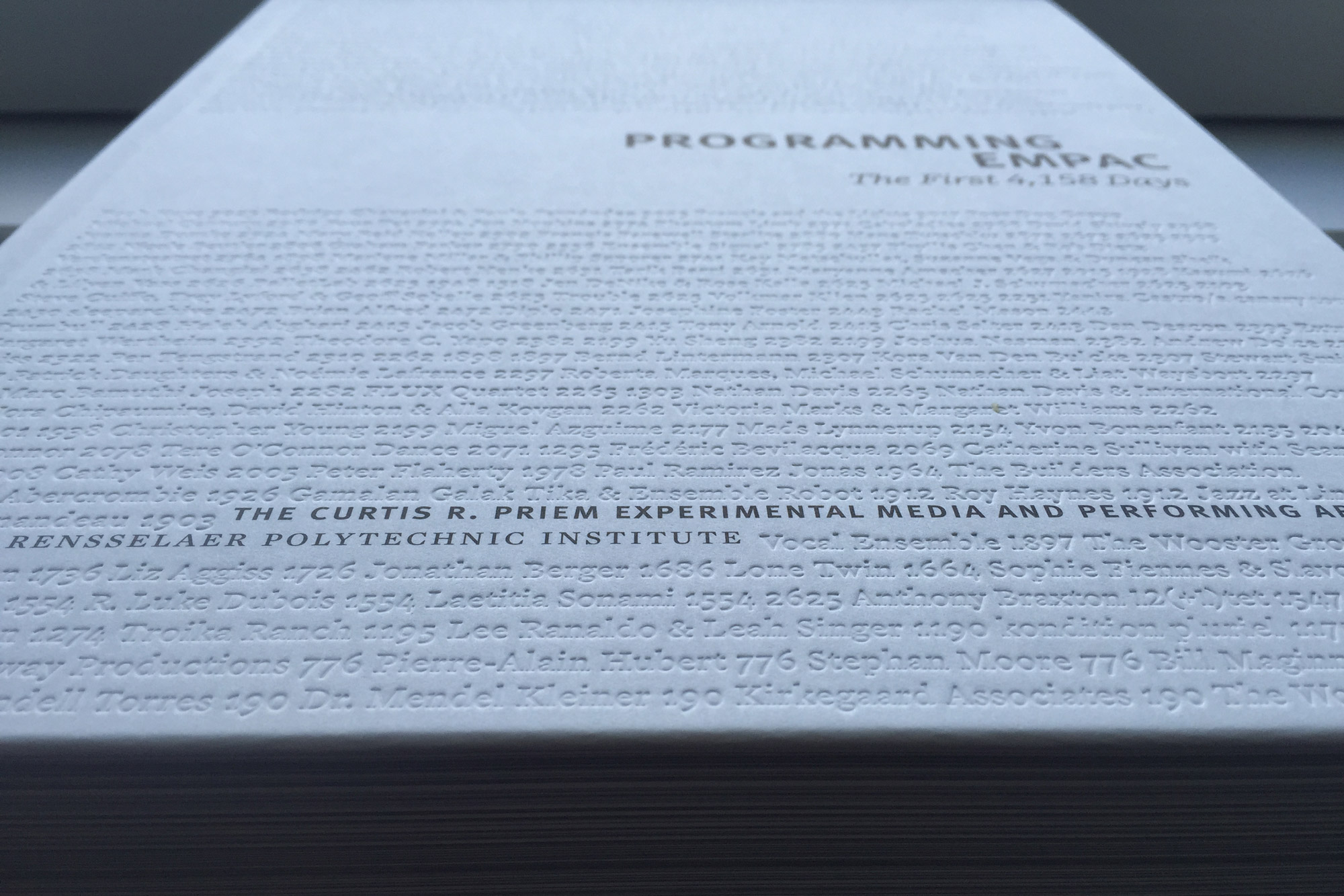 A white textured coffee table book, Programming EMPAC 