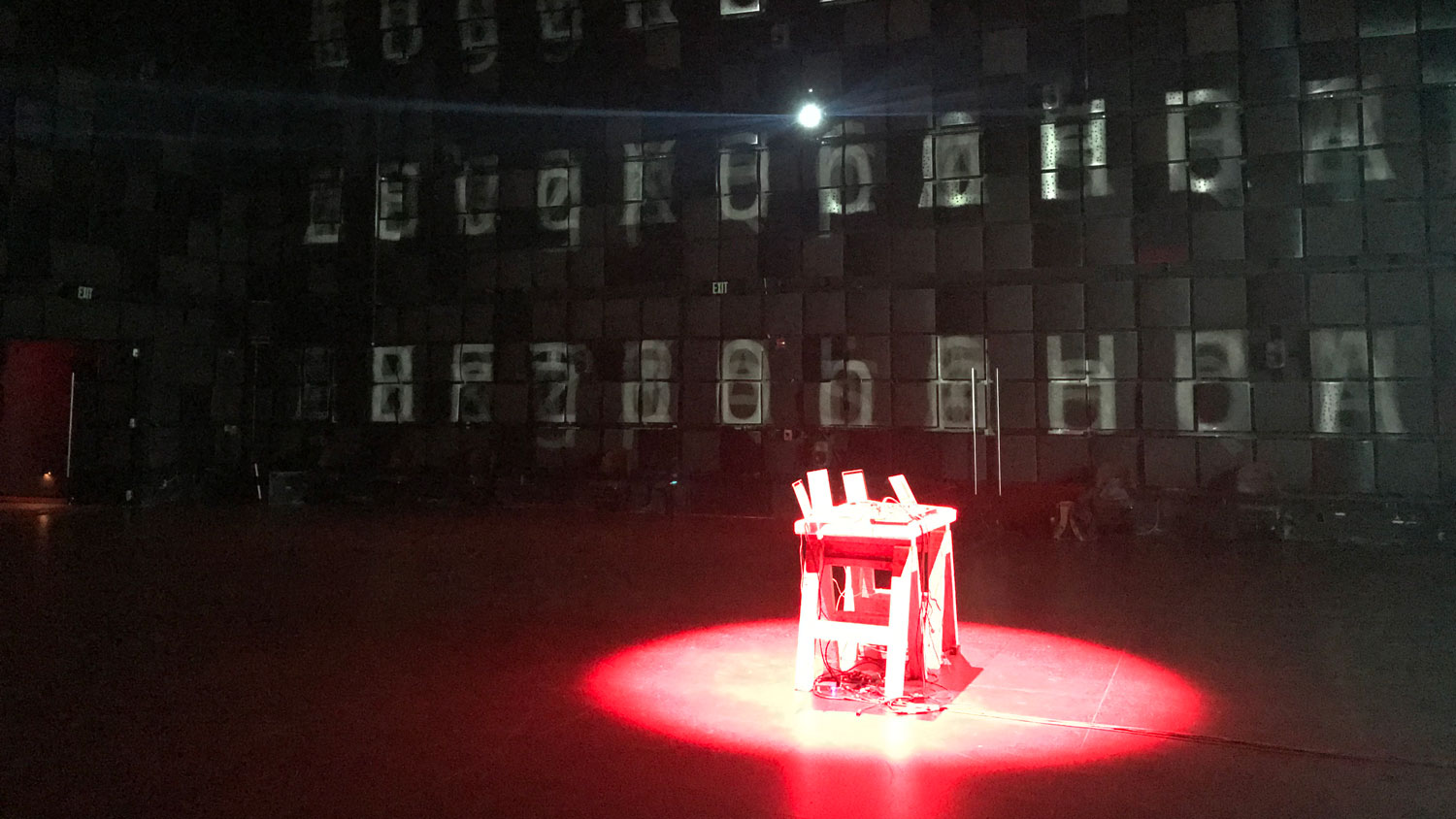 a table bathed in red with letters projected on the walls