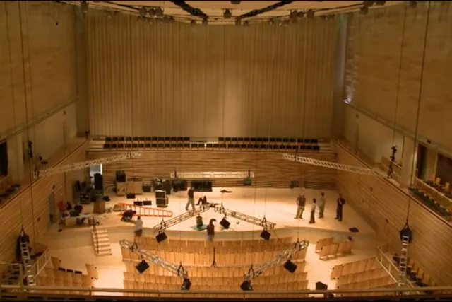 An aerial view of the concert hall as a crew work diligently on stage. 