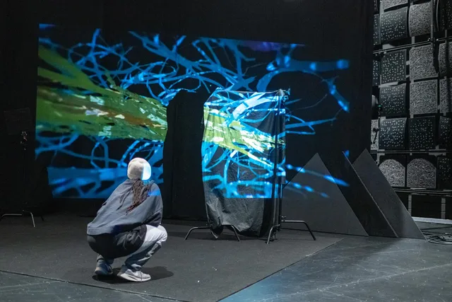 sage whitson looking on toward a projection in studio 1