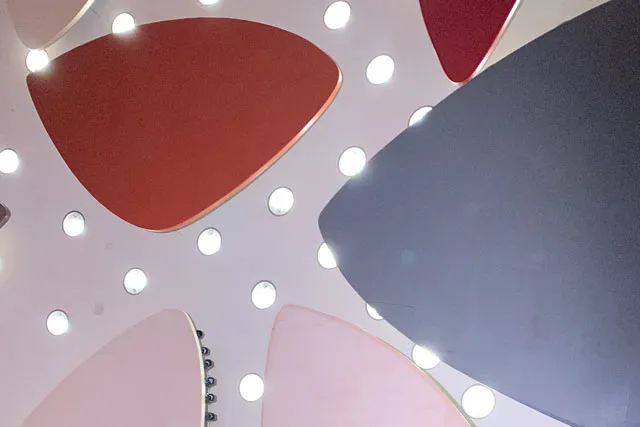 Various red, blue, and white, shapes on a background of dotted lights. 