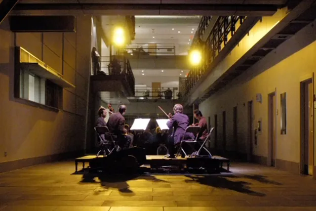 The Flux Quartet playing in a yellow lit hallway. 