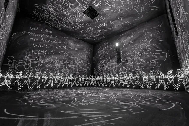 A room with walls, ceiling, and floor covered in child drawings of various people and doodles.