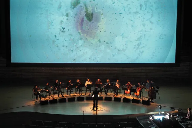 Ensemble Signal seated in a semi circle on stage recording in the concert hall. 