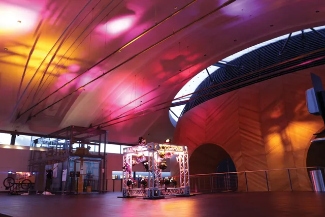 EMPAC Lobby lit in pink and orange spots of light via a lighting rig set up in the middle of the floor.