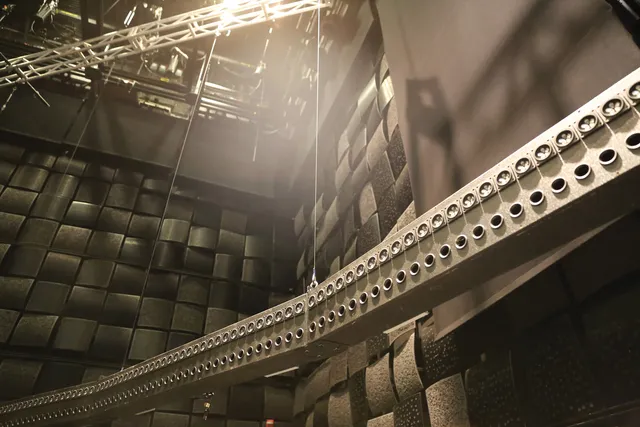 The wave field synthesis rig suspended from the ceiling of a black box studio.