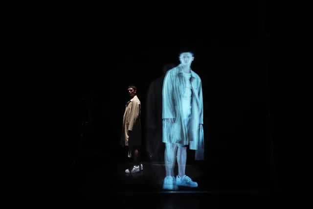 Wu Tsang standing next to hologram version of themself