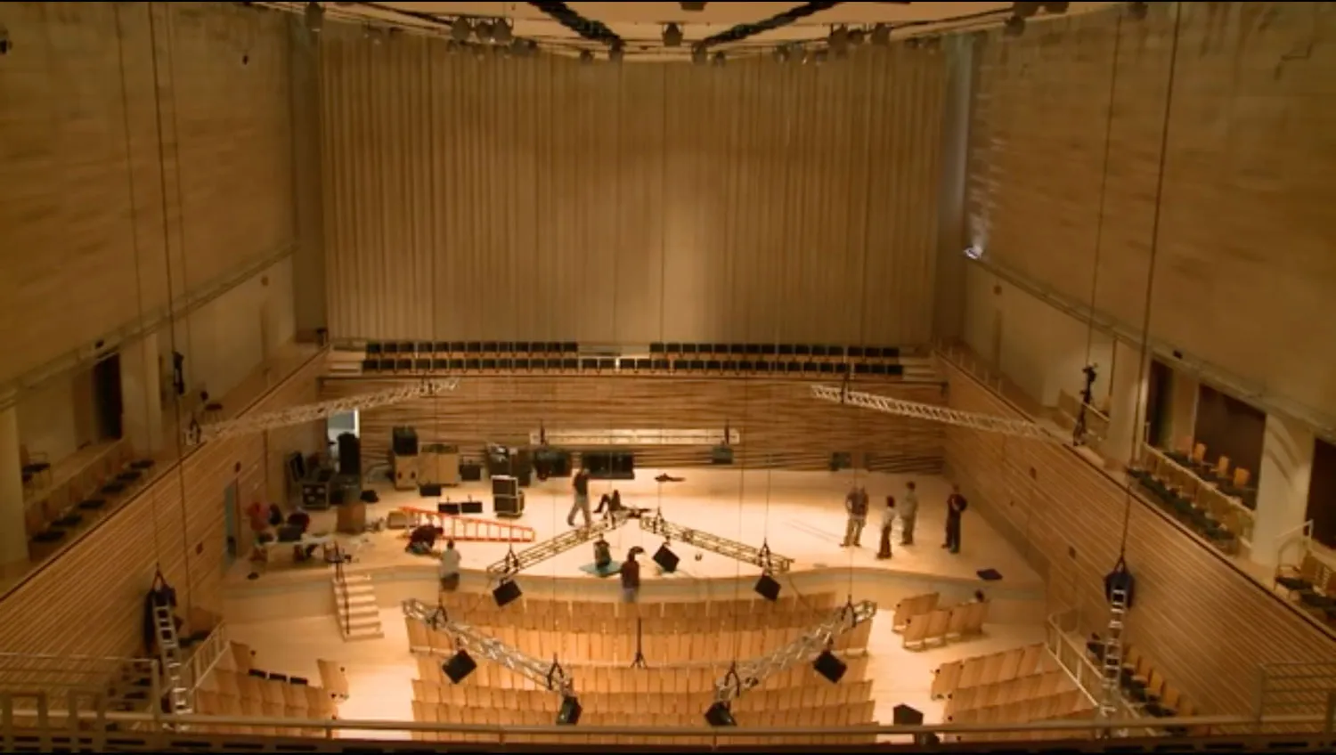 An aerial view of the concert hall as a crew work diligently on stage.