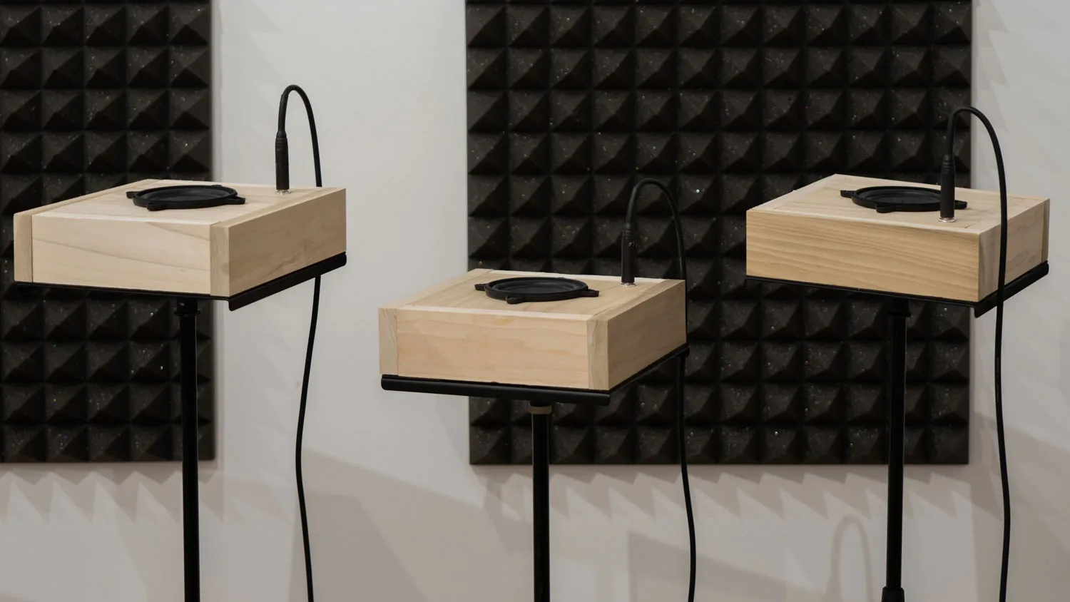 three square speakers on a pedestals