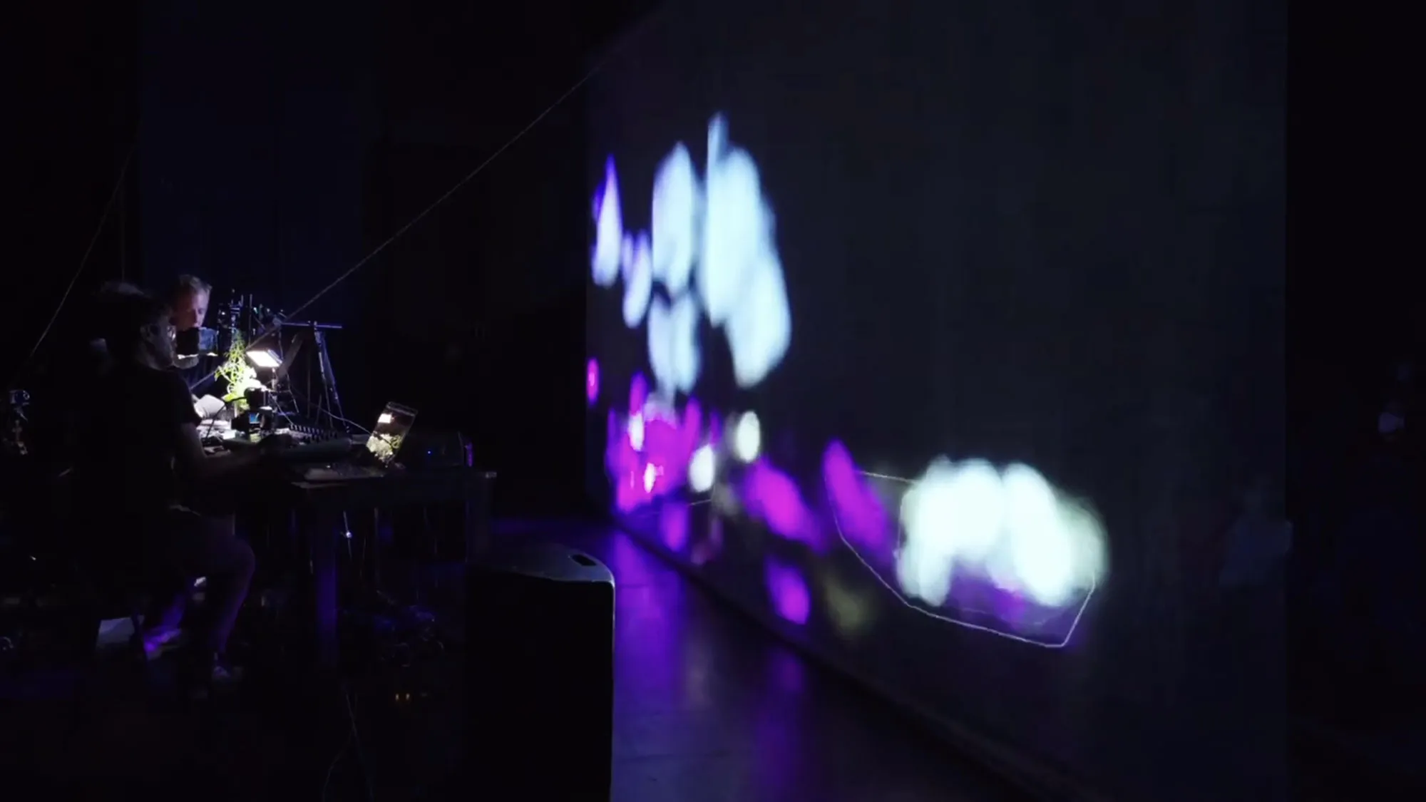 a person sitting at a projection table projecting a pixelated image on a screen 10' in front of them.