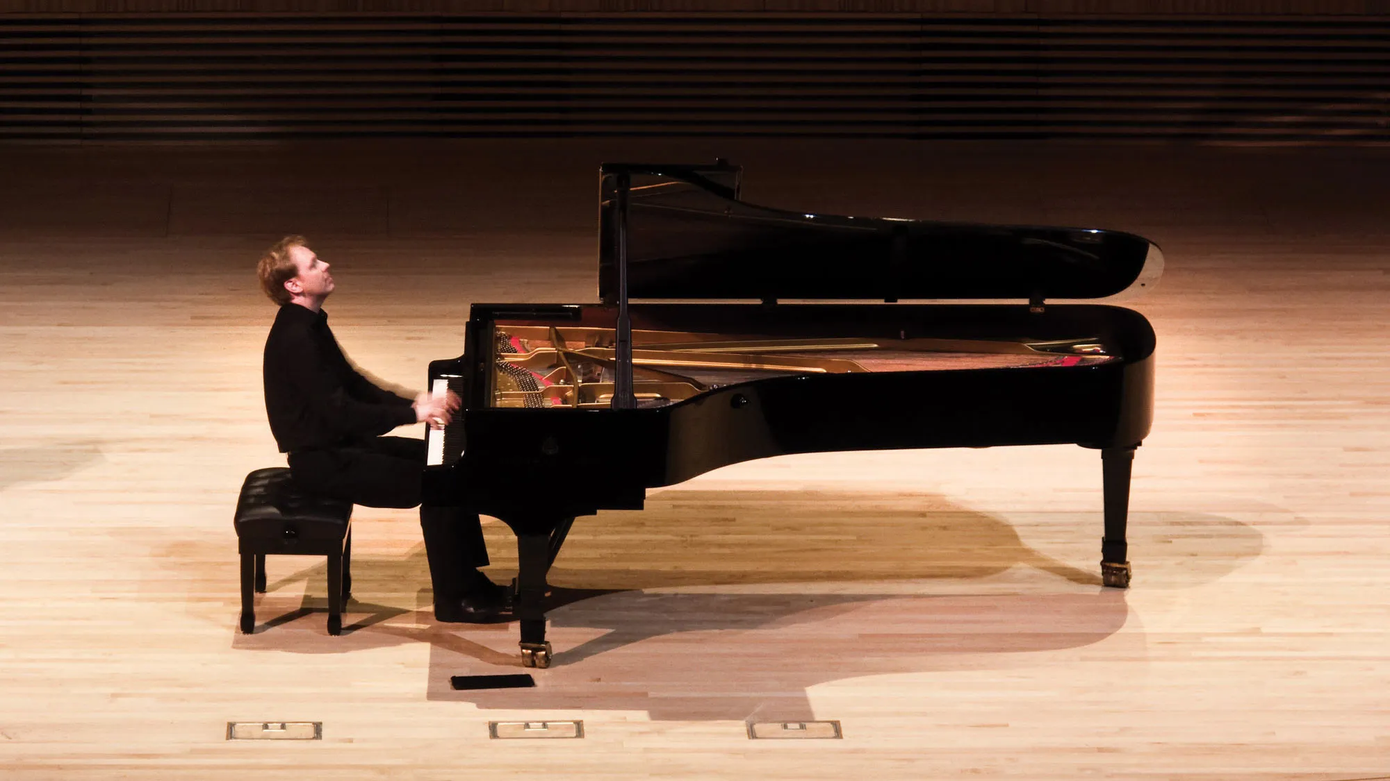 Per Tengstrand on the concert hall stage playing a grand piano.
