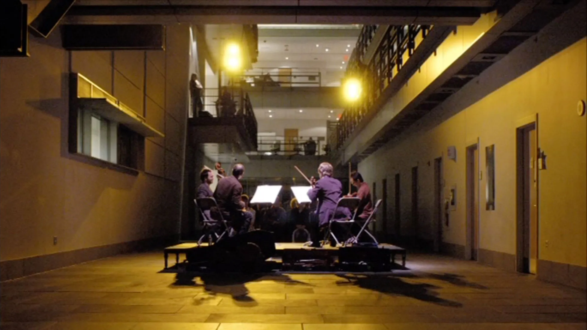 The Flux Quartet playing in a yellow lit hallway. 