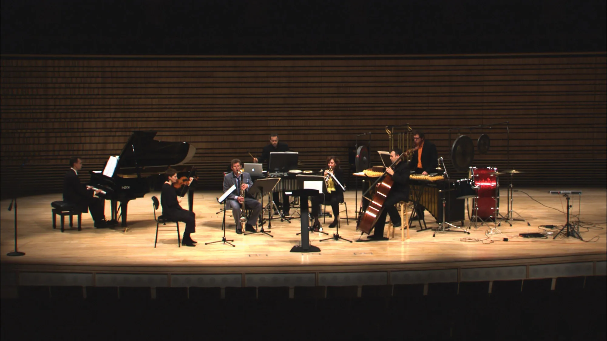 A small orchestra across the concert hall stage.